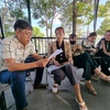 Các sinh viên trao đổi với phóng viên Thông tấn xã Việt Nam về việc đã hoàn tất học phí và thi tốt nghiệp nhưng không được cấp bằng Đại học đúng thời hạn. (Ảnh: TTXVN phát)