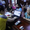Người dân đến nhận chi trả lương hưu, trợ cấp tại phường Cầu Dền, quận Hai Bà Trưng (Hà Nội) ngày 15/8/2023. (Ảnh: Hoàng Hiếu/TTXVN)