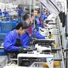 Công nhân làm việc tại nhà máy Jack Sewing Machine ở tỉnh Chiết Giang (Trung Quốc). (Ảnh: THX/TTXVN)