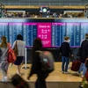 Hành khách kiểm tra thông tin các chuyến bay tại Sân bay Quốc tế Berlin Brandenburg (Đức). (Ảnh: AFP/TTXVN)