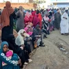 Người dân xếp hàng chờ nhận hàng cứu trợ tại Gedaref (Sudan), ngày 30/12/2023. (Ảnh: AFP/TTXVN)