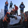 Nhân viên UNRWA phát hàng cứu trợ cho người dân Palestine tại Dải Gaza ngày 21/11/2023. (Ảnh: AFP/TTXVN)