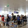 Hành khách xếp hàng vào khu vực soi chiếu kiểm tra an ninh tại Sân bay Tân Sơn Nhất. (Ảnh: Tiến Lực/TTXVN)