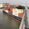 Tàu Phước Long 72 chở container số hiệu SG9838 trọng tải 4.600 tấn bị mắc kẹt dưới cầu Đồng Nai sáng 12/4, trước khi được cứu hộ và lai dắt đến nơi an toàn. (Ảnh: TTXVN phát)