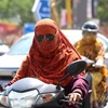 Người dân mặc áo chống nắng bảo vệ dưới thời tiết nắng nóng gay gắt tại Bhopal, bang Madhya Pradesh (Ấn Độ) hồi tháng Bảy năm ngoái. (Ảnh: THX/TTXVN)