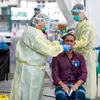 Nhân viên y tế lấy mẫu xét nghiệm COVID-19 cho người dân tại Singapore hồi năm ngoái. (Ảnh: AFP/TTXVN)