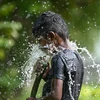 Trẻ em chơi đùa với nước để giải nhiệt trong ngày nắng nóng tại Chennai (Ấn Độ), ngày 28/5/2024. (Ảnh: AFP/TTXVN)