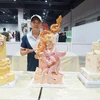 Anh Nguyễn Linh đoạt huy chương Bạc phần thi trang trí bánh cưới tại cuộc thi “Thách thức ẩm thực toàn cầu lần thứ 3” ở Kuala Lumpur (Malaysia). (Ảnh: Hằng Linh/TTXVN)