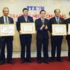 Tổng Giám đốc TTXVN Nguyễn Đức Lợi trao Kỷ niệm chương Vì sự nghiệp Thông tấn cho các đồng chí lãnh đạo Tổng Liên đoàn Lao động Việt Nam. (Ảnh: Doãn Đức/Vietnam+)