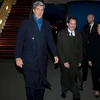 Ngoại trưởng Mỹ John Kerry (trái) được Đại sứ Mỹ ở Ba Lan Stephen Mull (phải) đón ở sân bay Warsaw, tối 4/11 (Nguồn: AFP)