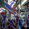 Người biểu tình chống chính phủ mang quốc kỳ Thái Lan tập trung trước trụ sở cảnh sát quốc gia ở Bangkok, ngày 4/12. (Nguồn: AFP/TTXVN)