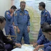 Đội tìm kiếm cứu nạn Malaysia làm việc với các nhân viên an ninh (Nguồn: AFP)
