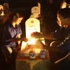 Thắp nến tri ân các liệt sỹ tại Nghĩa trang Liệt sỹ Quốc gia Đường 9. (Ảnh: Hồ Cầu/TTXVN)