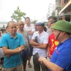 Bí Thư Huyện ủy Cô Tô Hoàng Bá Nam thăm hỏi động viên khách du lịch đang mắc kẹt lại trên đảo. (Ảnh: Thu Báu/TTXVN phát)