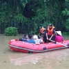Các chiến sỹ Công an Quảng Ninh giúp dân di chuyển an toàn qua chỗ ngập sâu. (Ảnh: Nguyễn Hoàng/TTXVN)