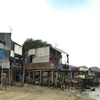 Các căn nhà tạm ở cửa sông Cái, thành phố Nha Trang luôn có nguy cơ bị sập khi triều cường xâm thực sẽ được bố trí lại chỗ ở. (Ảnh: Nguyên Lý/TTXVN)