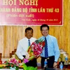 Ông Mai Văn Chính, Ủy viên Trung ương Đảng, Phó trưởng Ban Tổ chức Trung ương (phải) tặng hoa chúc mừng ông Phạm Văn Tân. (Ảnh: Thanh Tân/TTXVN)
