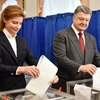 Tổng thống Ukraine Petro Poroshenko (phải) và phu nhân bỏ phiếu tại một địa điểm bầu cử ở Kiev. (Nguồn: AFP/TTXVN)