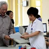 Nhân viên y tế Bệnh viện Bạch Mai hướng dẫn người khám chữa bệnh giải quyết thủ tục. (Ảnh: Dương Ngọc/TTXVN)