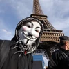 Một người biểu tình đeo mặt nạ Anonymous Guy Fawkes, biểu tượng của Anonymous trong một cuộc tuần hành dưới chân tháp Eiffel, Paris. (Nguồn: AFP) 