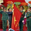 Ông Huỳnh Ngọc Sơn,Phó Chủ tịch Quốc hội gắn Huân chương Quân công hạng Nhất lên Quân kỳ Quyết thắng của Quân khu 7. (Ảnh: Thế Anh/TTXVN)