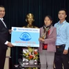 Chủ tịch thành phố Đà Nẵng Huỳnh Đức Thơ trao bảng tượng trưng quyết định cấp căn nhà cho bà Nguyễn Thị Tần. (Ảnh: Trần Lê Lâm/TTXVN)