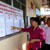 Chủ tịch Quốc hội Nguyễn Thị Kim Ngân kiểm tra nơi niêm yết danh sách cử tri tại khu phố Minh Phú, huyện Châu Thành. (Ảnh: Trọng Đức/TTXVN)