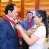 Thiếu niên Thủ đô Hà Nội đeo khăn quàng đỏ cho Chủ tịch nước Trần Đại Quang. (Ảnh: Nhan Sáng/TTXVN) 
