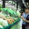 Người tiêu dùng lựa chọn sản phẩm theo tiêu chuẩn VietGap tại hệ thống siêu thị Co.op mart Thành phố Hồ Chí Minh. (Ảnh: Thanh Vũ/TTXVN)