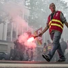 Một người biểu tình cầm pháo sáng trong cuộc tuần hành ở Lyon. (Nguồn: AP)