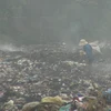 Rác vẫn âm ỉ cháy tại bãi rác xã Trường Thủy khiến khói bụi mù mịt. (Ảnh: Đức Thọ/TTXVN)