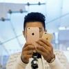 Một người đàn ôngtử chụp ảnh với hai mẫu iPhone 6s và 6s Plus trong một cửa hàng Apple Store ở Bắc Kinh.(Nguồn: gadgetsmade.com)