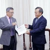 Thứ trưởng Bộ Ngoại giao Vũ Hồng Nam trao Quết định cho ông Dinh Jean-Pierre. (Ảnh: An Đăng/TTXVN)