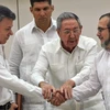 Thủ lĩnh FARC Timoleon Jimenez (phải) và Tổng thống Colombia Juan Manuel Santos (trái), Chủ tịch Cuba Raul Castro (giữa) tại lễ ký kết thỏa thuận hòa bình ở La Habana. (Nguồn: AFP/TTXVN)