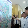 Phó Thủ tướng Trịnh Đình Dũng cùng các đại biểu xem bản đồ Quy hoạch giao thông vận tải thủ đô Hà Nội đến năm 2030 - Tầm nhìn đến năm 2050. (Ảnh: Tuấn Anh/TTXVN)