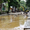 Huy động máy xúc, san gạt, dọn dẹp bùn đất trên đường Thanh Niên, phường Hồng Hà, thành phố Yên Bái. (Ảnh: Thế Duyệt/TTXVN)
