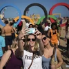 Khách du lịch chụp ảnh tại một bãi biển ở Rio de Janeiro trong dịp Olympic. (Nguồn: Xinhua)