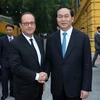 Chủ tịch nước Trần Đại Quang đón Tổng thống Pháp Francois Hollande. (Ảnh: Nhan Sáng/TTXVN)