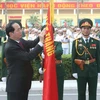 Chủ tịch nước Trần Đại Quang gắn Huân chương Độc lập hạng Nhì lên cờ truyền thống của Học viện. (Ảnh: Nhan Sáng/TTXVN)