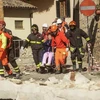 Nhân viên cứu hộ giúp đỡ một phụ nữ cao tuổi sau trận động đất ở Norcia, ngày 30/10. (Nguồn: AFP/TTXVN)