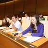 Đại biểu Quốc hội tỉnh Bắc Giang biểu quyết thông qua Luật tín ngưỡng, tôn giáo. (Ảnh: Phương Hoa/TTXVN)