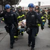 Nhân viên thuộc Sở Cứu hỏa và Sở Cảnh sát thành phố New York chuyển người bị thương khỏi hiện trường vụ tai nạn hôm 4/1. (Nguồn: AFP/TTXVN)