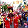 Người dân và du khách xem rước kiệu bà Thiên Hậu trên phố trong Lễ hội chùa Bà Thiên Hậu ở thành phố Thủ Dầu Một. (Ảnh: Huyền Trang/TTXVN)