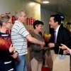 Ông Bùi Tá Hoàng Vũ, Giám đốc Sở du lịch Thành phố Hồ Chí Minh tặng quà cho đoàn khách du lịch quốc tế đầu tiên trong năm 2017. (Ảnh: An Hiếu/TTXVN)