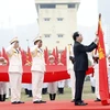 Chủ tịch nước Trần Đại Quang gắn Huân chương Chiến công hạng Nhất lên cờ truyền thống của đơn vị. (Ảnh: Nhan Sáng/TTXVN)