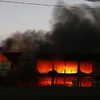 Lửa vẫn cháy dữ dội tại khu vực phía sau tòa nhà công ty Kwong Lung-Meko, ngày 23/3. (Ảnh: Thanh Liêm/TTXVN)