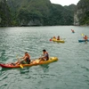 Du khách bơi thuyền Kayak trên Vịnh Hạ Long. (Ảnh: Tiến Dũng/TTXVN)