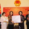 Phó Chủ tịch nước Đặng Thị Ngọc Thịnh trao tặng Trường PTTH số 14 mang tên Chủ tịch Hồ Chí Minh quà tặng là một số trang thiết bị phục vụ hoạt động dạy và học. (Ảnh: Quang Hải/TTXVN)