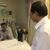 Đại sứ Việt Nam Nguyễn Tiến Minh thăm hỏi anh Phan Minh Dương, một trong ba thuyền viên gặp tai nạn khi đang làm việc trên tàu Le Tong Patriot, Singapore. (Ảnh: Mỹ Bình/Vietnam+)