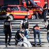 Cảnh sát khám nghiệm hiện trường trên đại lộ Champs-Elysees ở Paris sau vụ xe ôtô lao vào xe cảnh sát ngày 19/6. (Nguồn: AFP/TTXVN)